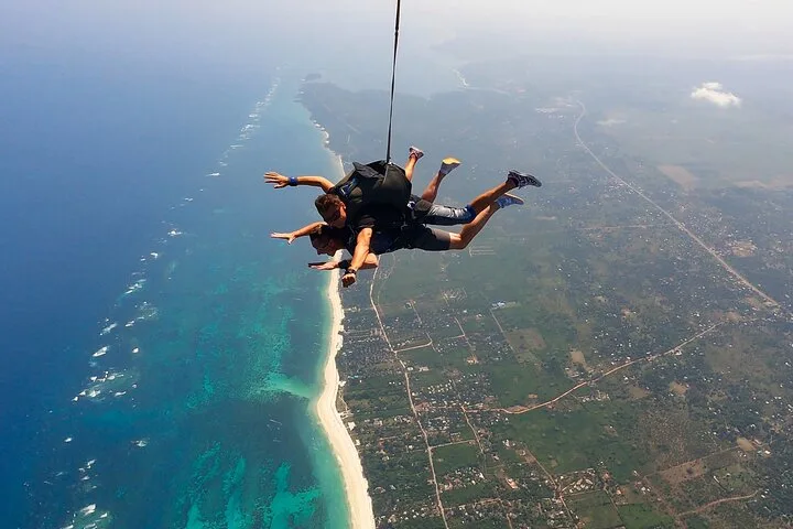 Tandem skydivers in freefall above Diani Beach and the Indian Ocean in Kenya